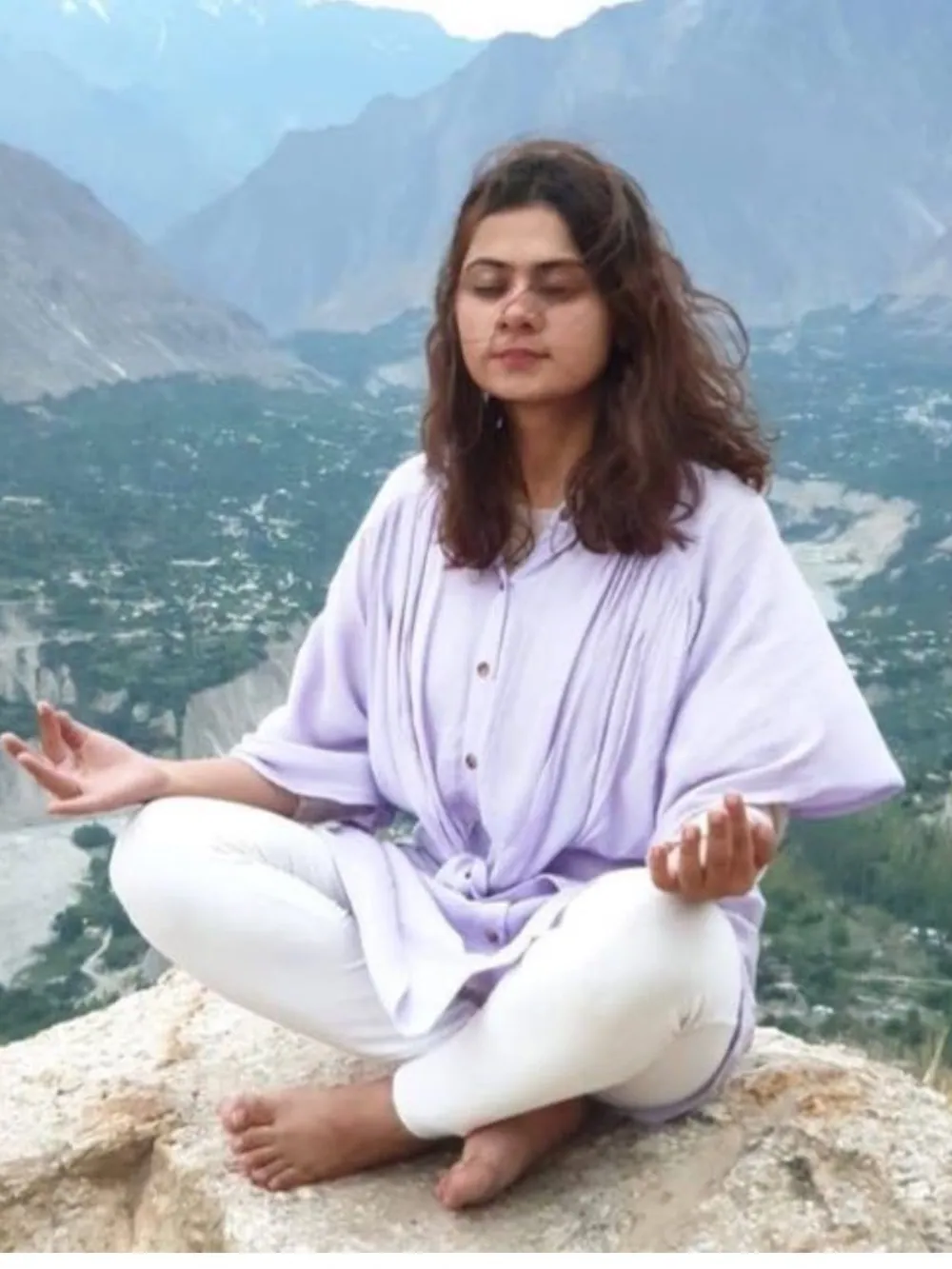 A woman sitting quietly in a green field